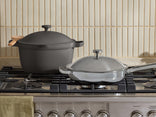 Two cookware items on a stove with a neutral background