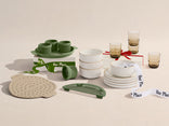Dishes and kitchenware with 'Our Place' branding on a beige background