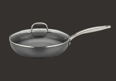 Frying pan with a lid on a black background
