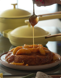 Dessert being drizzled with syrup on a plate with a blurred background