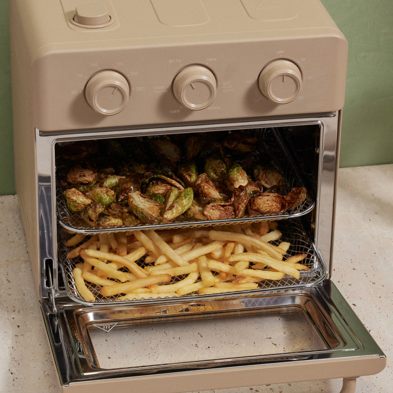 Beige oven with food items inside on a countertop