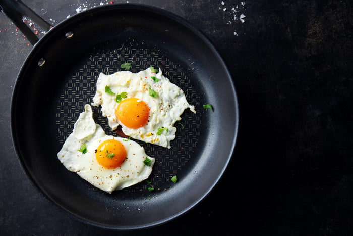 Pan with two eggs cooking inside