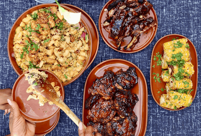 Pasta and ribs on platters on a table 
