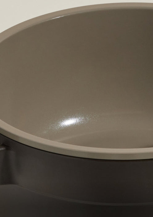 Close-up view of a round, brown ceramic bowl with a smooth, glossy interior surface.