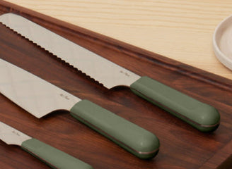 sage serrated knife, everyday chefs knife, and paring knife on walnut cutting board