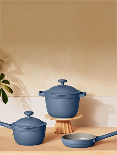 Three blue pans on a wooden countertop