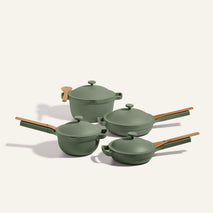 The Cookware Set includes four green nonstick pots and pans with matching lids and light brown handles, displayed on a neutral background—ideal for fans of the Perfect Pot or Always Pan.