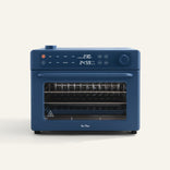 Wonder Oven Pro: Blue countertop 8-in-1 air fryer oven with digital display, control knobs, buttons, and glass door showing versatile interior racks.