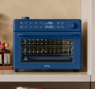 Blue Our Place air fryer oven with a digital display showing 230 degrees and a 24:59 timer.