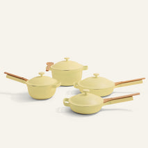 The Cookware Set includes four yellow pieces with wooden handles and matching lids, shown on a light background—an ideal choice for anyone seeking a versatile Perfect Pot alternative.