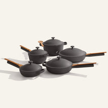 The Cookware Set+ features five black nonstick pieces with wooden handles and lids, displayed on a light background.