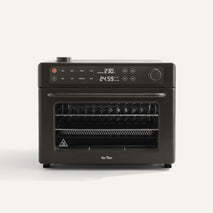 The Wonder Oven Pro, in black, features a digital display for temperature and time, top buttons and dials, plus multiple wire racks inside on a plain background.