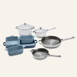 Titanium Pro Cookware + Bakeware Set 2.0 containing two stainless steel pots with lids, two stainless steel frying pans, and three blue ceramic bakeware dishes.