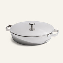 The Titanium Braiser Pro 28 cm, featuring two handles and a fitted lid, sits on a plain, light background.