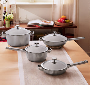 Set of silver cookware on a table with a kitchen background