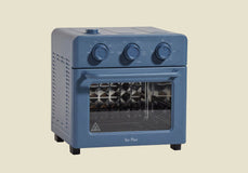 A blue countertop toaster oven with three control knobs, a glass door, and a visible metal rack inside, against a plain background.