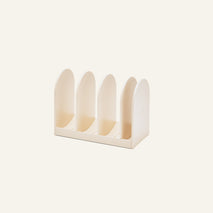 The Universal Storage is a beige plastic organizer with four upright dividers for files, books, cookware, or Wonder Oven accessories, shown on a plain light background.