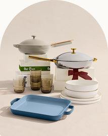 Collection of kitchenware including pots, pans, and glasses on a neutral background