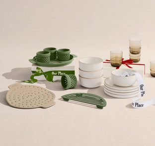 Table setting with green and white ceramic items on a beige background