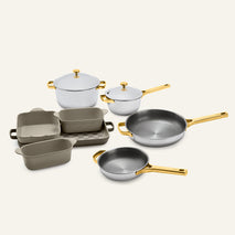 Titanium Pro Cookware + Bakeware Set 2.0 featuring stainless steel pots, frying pans, and baking dishes with gold-colored handles and lids.
