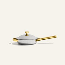 Titanium Always Pan Pro 20 cm 2.0: a small silver stainless steel frying pan with a matching lid, featuring gold-toned handles and lid knob.