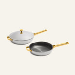 Titanium Pro Always Pan Duo 2.0 set including two white non-toxic frying pans with gold-toned handles, one with a matching lid.