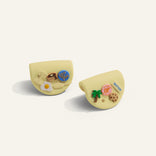 Two yellow cat-shaped cookies with decorative elements on a white background