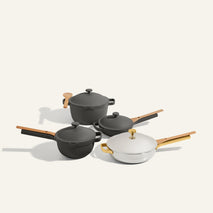 The Titanium & Ceramic Cookware Set features two saucepans, a deep pot, and a shallow Always Pan with wooden handles, all shown on a light background.