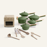 A cream oven and a set of green cookware on a white background