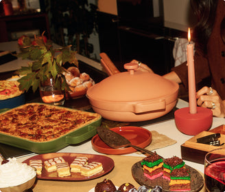Dessert table with various treats including a pizza, pastries, and a colorful cake.