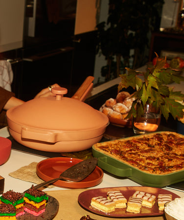 A countertop with cookware, food, and candles on it