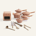 Set of pink cookware and white plates on a white background