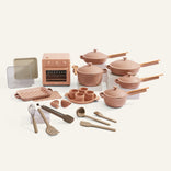 Set of pink cookware and white plates on a white background