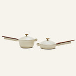 The Mini Cookware Duo, featuring two beige nonstick bestsellers with wooden handles and lids—a multifunctional deep pot and a shallow pan—are displayed side by side on a plain light background.