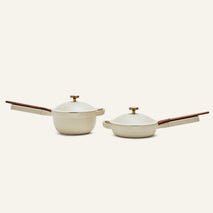 The Mini Cookware Duo, featuring two beige nonstick bestsellers with wooden handles and lids—a multifunctional deep pot and a shallow pan—are displayed side by side on a plain light background.