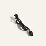 A black power cord with a two-prong plug at one end and a three-hole connector at the other, placed on a plain light background.